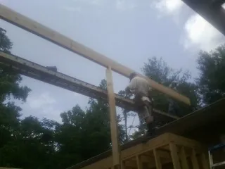 Carpenter setting a ridge beam over a new addition frame in Rohnert Park