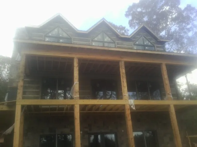 Dormers and porch framing on a large log home under construction — Roof Coating work by our crew in Rohnert Park