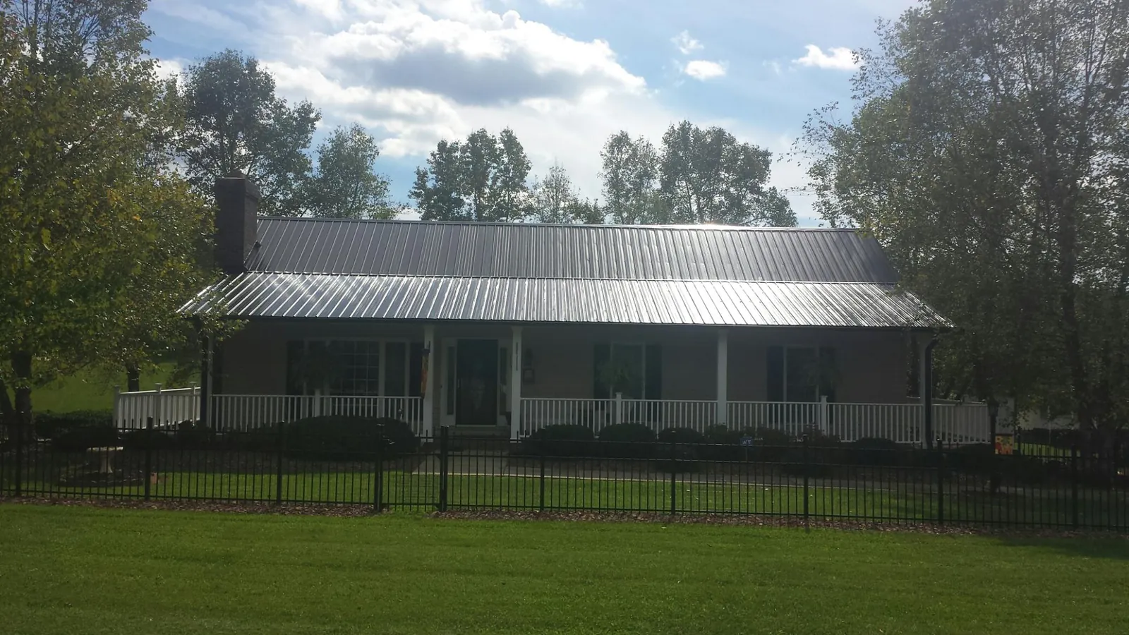 Gray metal roof on a brick ranch with a full width front porch — Gutter Guard Installation work by our crew in Rohnert Park